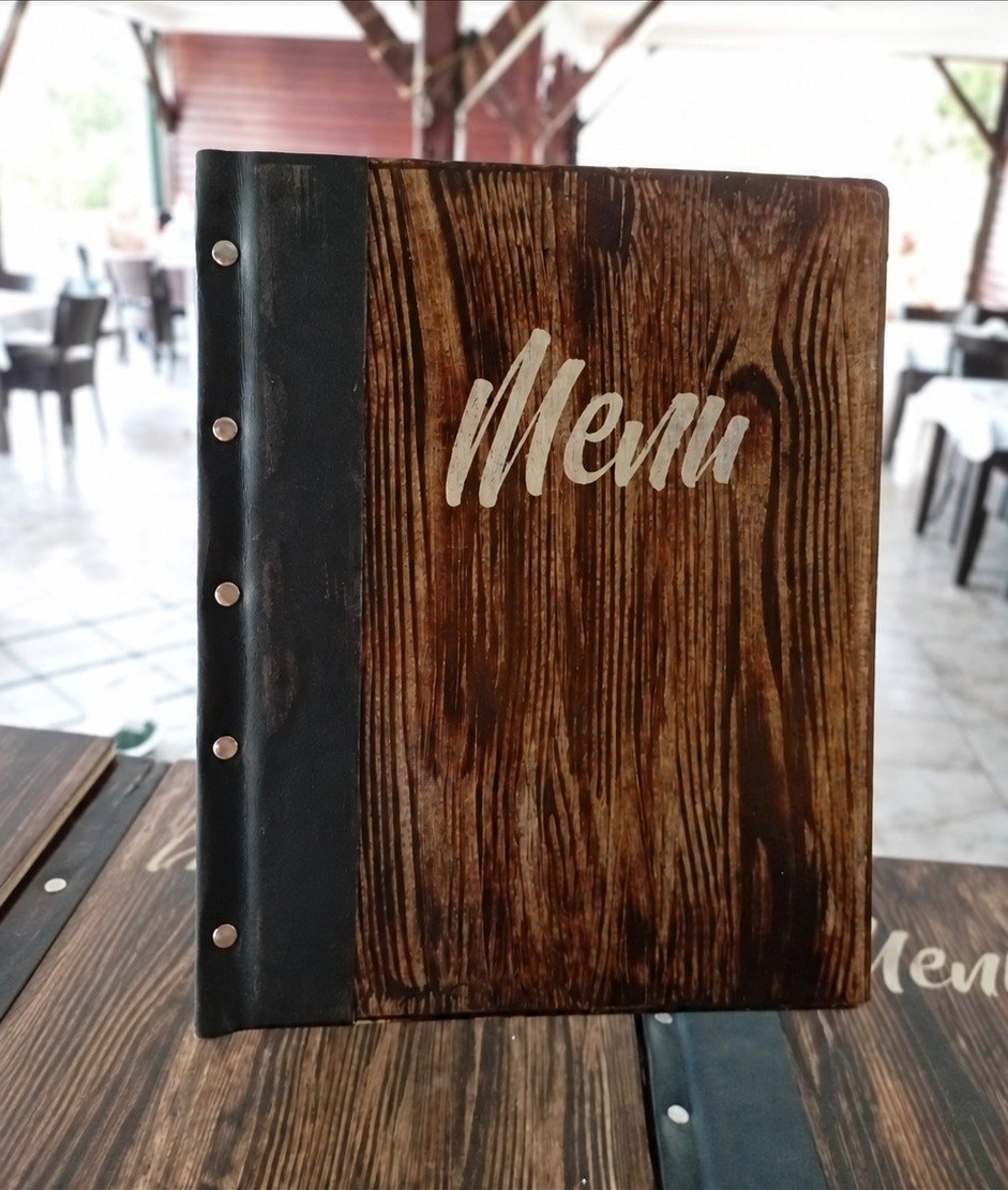 Tamni jelovnik s natpisom Menu na stolu lokala